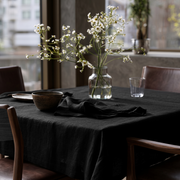 Black Square Linen Tablecloth in a Contemporary Dining Room with Brown Leather Chairs and Large Windows