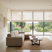 Cream Roman Blinds in a Living Room with Light Neutral Walls and a Beige Sectional Sofa