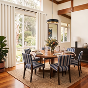 Cream Linen Eyelets Dining Room Curtain in a Transitional Dining Room with White Walls and Striped Upholstered Chairs Around a Round Wooden Table - Blackout Lining