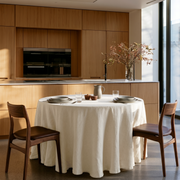 Cream Linen Round Tablecloth in a Modern Kitchen Dining Nook with Warm Oak Cabinetry and Brown Leather Chairs