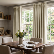Ecru Heavy Weight Linen Pinch Pleat Curtains in a Traditional Dining Room with Brick Accent Wall and Upholstered Chairs