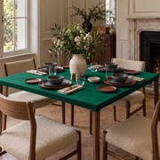 Emerald Green Fitted Square Velvet Tablecloth in a Transitional Dining Room with a Marble Fireplace and Cream Upholstered Chairs