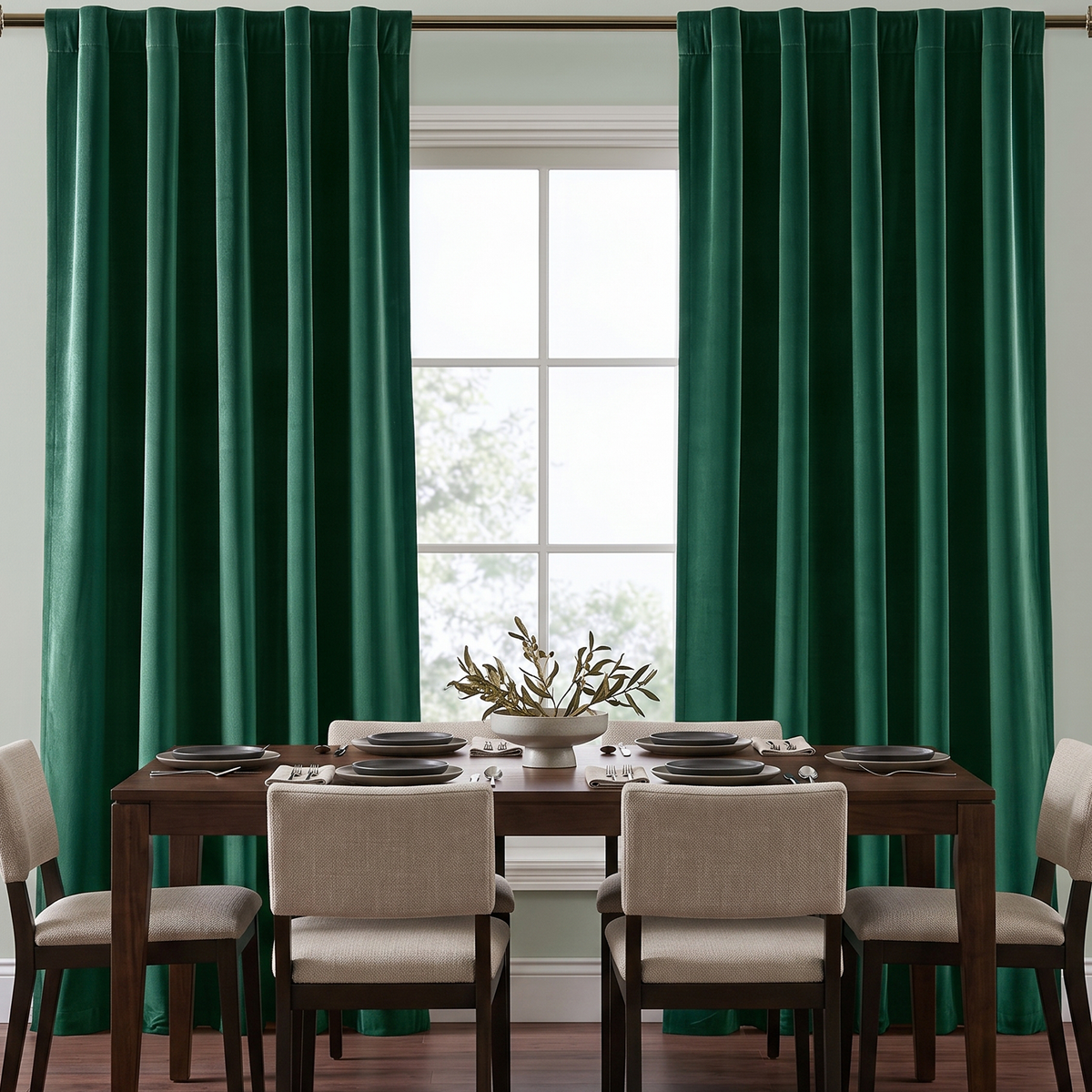 Elegant dining room with emerald green back-tab curtains, dark wooden furniture, and neutral chairs.
