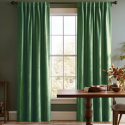 Warm dining room with green back-tab curtains, dark wooden furniture, and soft natural light.
