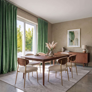 Modern dining room with green rod-pocket curtains, mid-century furniture, and warm natural light.
