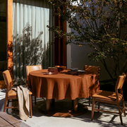 Terracotta Heavy Weight Linen Round Tablecloth in a Sunlit Patio Dining Space with Tan Leather Chairs