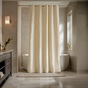 Cream shower curtain in a modern bathroom with a freestanding bathtub.