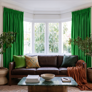 Lime Green Velvet Pencil Pleat Curtains in a Bay Window Living Room with Cream Walls and a Brown Leather Sofa