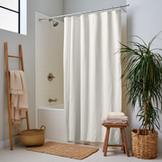 Off White Linen Button-Hole Top Weighted Shower Curtain next to a Wooden Ladder Towel Rack