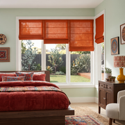 Burnt Orange Linen Cordless Roman Blinds in a Rustic Bedroom with Sage Green Walls and a Red Quilted Bedding Set