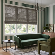 Heavy Natural Roman Blinds in a Modern Living Room with Green Striped Wallpaper and a Velvet Sofa