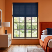 Royal Blue Linen Cordless Roman Blinds in a Modern Bedroom with Orange Walls, an Orange Velvet Bed