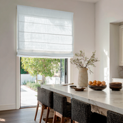 White Linen Kitchen Roman Blinds in a Modern Kitchen with White Walls, Marble Island and Woven Chairs