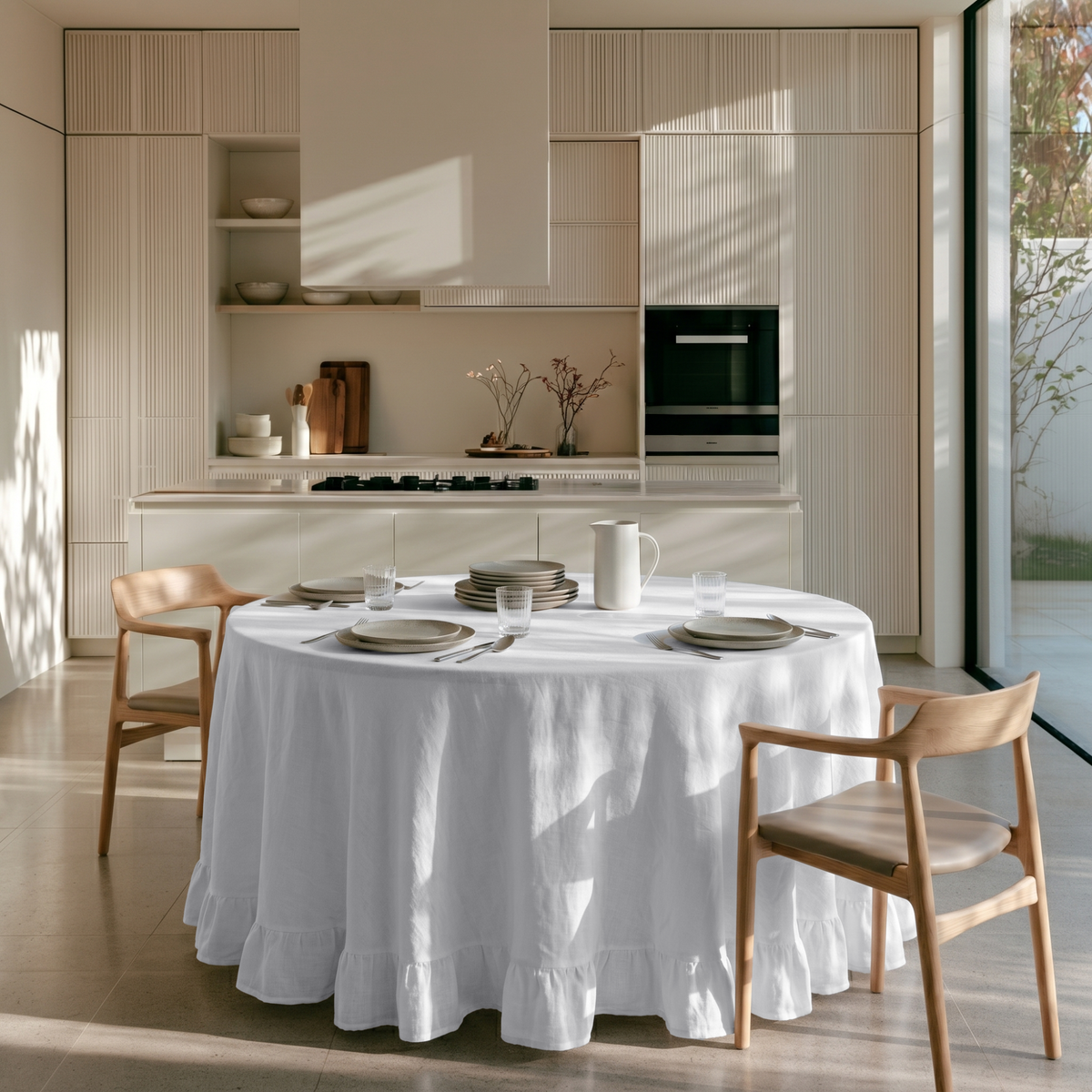 White Linen Round Ruffle Tablecloth in a Sunlit Kitchen with Cream Fluted Cabinetry and Light Wood