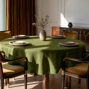 Moss Green Linen Round Tablecloth in an Elegant Dining Room with Ivory Paneled Walls and Walnut Wood and Amber Velvet Accents