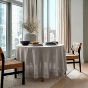 Natural Linen Round Tablecloth in a Bright City Dining Nook with Floor-to-Ceiling Windows