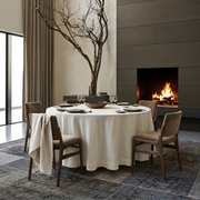 Off-White Linen Round Tablecloth in a Modern Dining Room with Fireplace and Warm Wood Accents