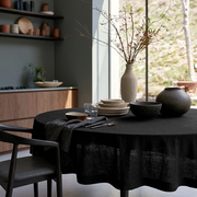 Black Linen Round Tablecloth in a Modern Kitchen Dining Space with Soft Gray Walls and Walnut Wood