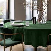 Forest Green Linen Round Tablecloth in a Modern Dining Room with Warm Taupe Walls and Deep Green Velvet Chairs