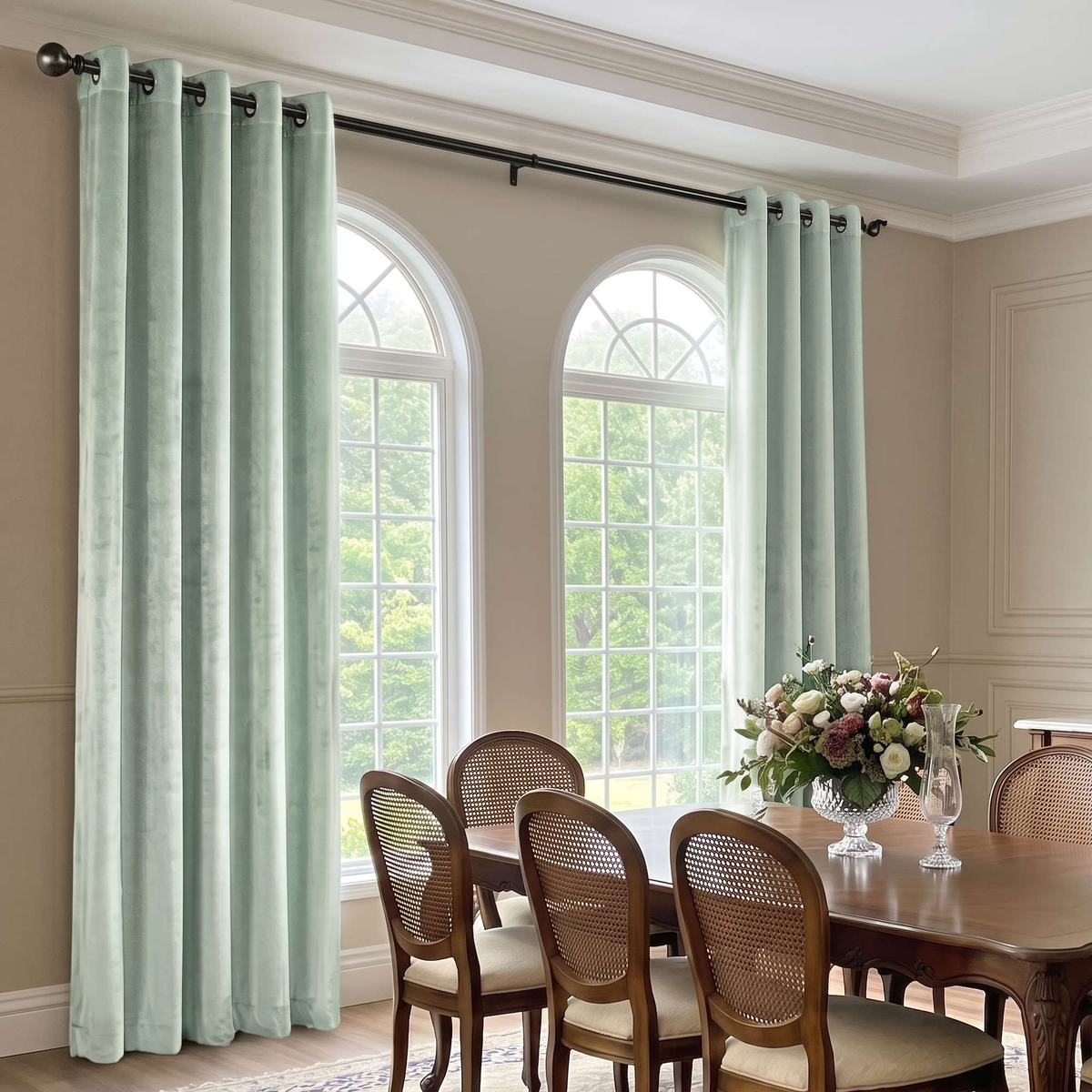 Elegant dining room with pale mint grommet curtains, cane-back chairs, and graceful arched windows.
