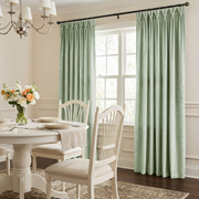 Elegant dining room with pale sage pinch-pleat curtains, white furniture, and delicate floral décor.