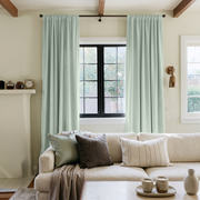 Mint Green Velvet Rod Pocket Curtains in a Modern Living Room with a Cream Bouclé Sofa and Black Framed Windows
