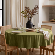 Moss Green Round Velvet Tablecloth in a Contemporary Dining Room with Cream Curtains and Cane Chairs