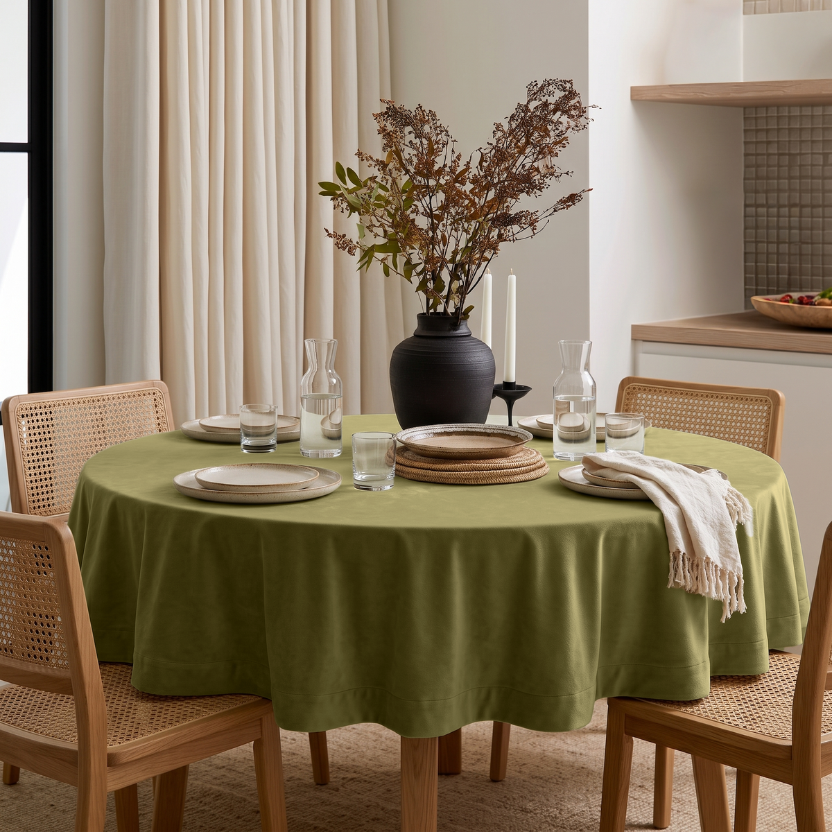 Moss Green Round Velvet Tablecloth in a Contemporary Dining Room with Cream Curtains and Cane Chairs
