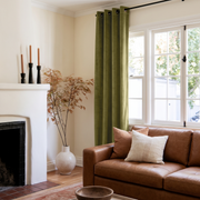 Moss Green Velvet Eyelet Curtains in a Modern Living Room with Cream Walls and a Caramel Leather Sofa