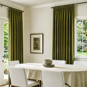 Bright dining room with olive green rod-pocket curtains, white furniture, and garden views