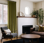 Moss Green Velvet S-Fold Curtains in a Mid-Century Living Room with a White Tiled Fireplace and Brown Leather Sofa