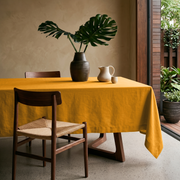 Mustard Yellow Rectangular Linen Tablecloth in a Minimalist Dining Room with Tropical Greenery