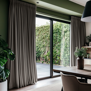 Natural Heavy Weight Linen Pencil Pleat Curtains for Sliding Door in a Modern Dining Room with Green Walls, Black Window Frames and Lush Greenery - Blackout Lining
@Heading: Pencil Pleat