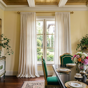 Off-White Linen Rod Pocket Curtains In A Formal Dining Room With Yellow Walls And Dark Wood Flooring Beneath A Gold-Trim Tray Ceiling.