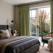 Olive Green Velvet Pencil Pleat Sliding Patio Door Curtains in a Modern Bedroom with Gray Bedding and a Black Cane Chair