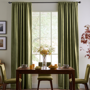 Cozy dining room with olive green rod-pocket curtains, dark wooden furniture, and warm autumn accents.

