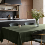 Sage Green Rectangular Linen Tablecloth in a Modern Kitchen Dining Area with Dark Cabinetry and White Floral Arrangement