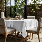 White Rectangular Linen Tablecloth in a Modern Outdoor Dining Area with Brick Wall