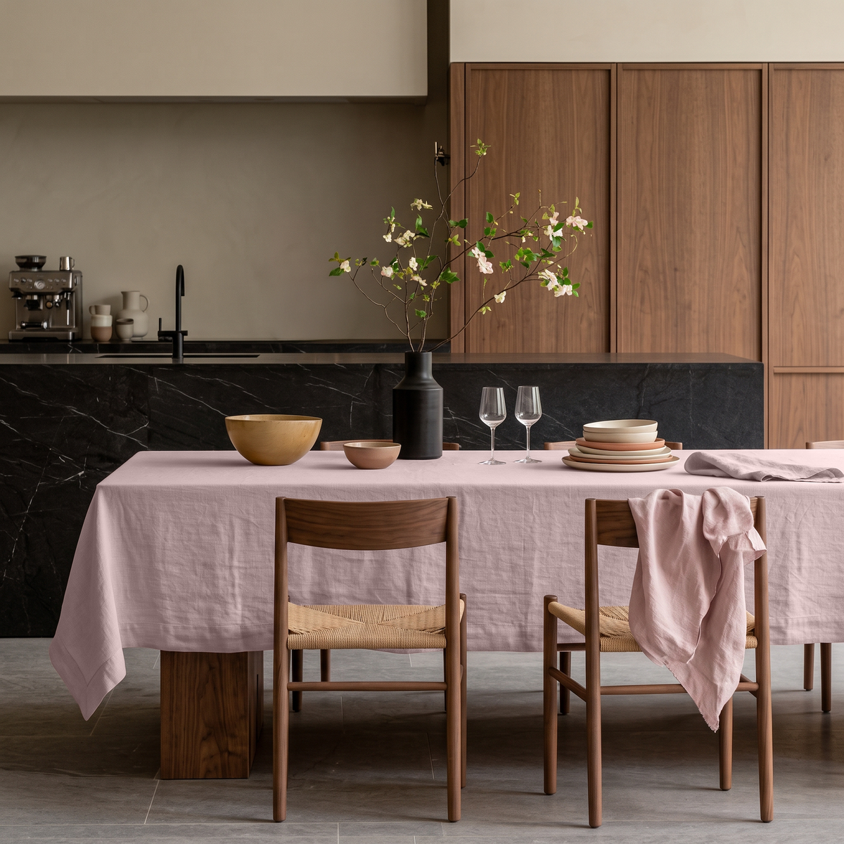 Dusty Pink Rectangular Linen Tablecloth in a Modern Contemporary Kitchen with Walnut Cabinetry and Black Marble Island