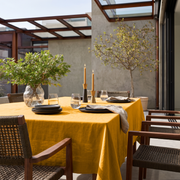 Mustard Yellow Rectangular Linen Tablecloth in a Contemporary Outdoor Dining Area with Woven Chairs