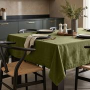 Olive Green Rectangular Linen Tablecloth in a Modern Dining Room with Woven Chairs and Neutral Tableware