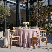 Dusty Pink Linen Round Ruffle Tablecloth in an Outdoor Patio Dining Space with Natural Wood and Cream Textiles