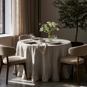 Natural Linen Round Ruffle Tablecloth in a Moody Dining Room with Taupe Drapery and Cream Bouclé Chairs