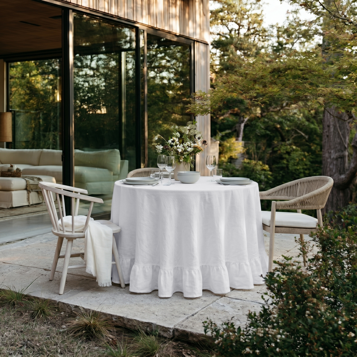 White Linen Round Ruffle Tablecloth in an Outdoor Patio Dining Space with Natural Stone and White Wood