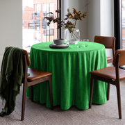 Lime Green Round Velvet Tablecloth in a Contemporary Dining Room with City Views and Brown Leather Chairs