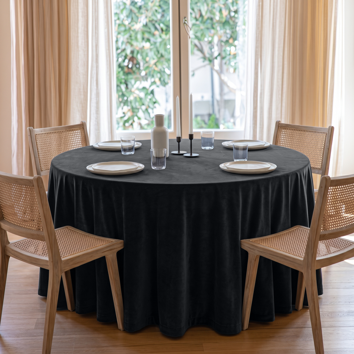 Steel Black Round Velvet Tablecloth in a Bright Dining Room with Sheer Drapes and Cane Chairs