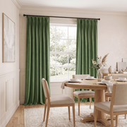 Serene dining room with sage green pinch-pleat curtains, light wooden furniture, and soft neutral déc

