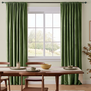 Cozy dining room with sage green rod-pocket curtains, warm wooden furniture, and countryside views.
