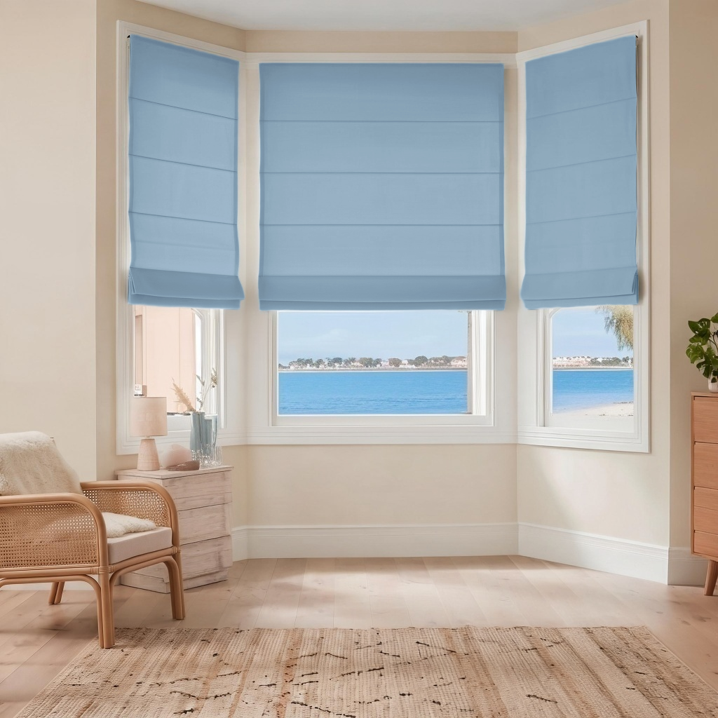 Sky Blue Cordless Linen Roman Blinds in a Coastal Bedroom with Cream Walls and a Rattan Armchair