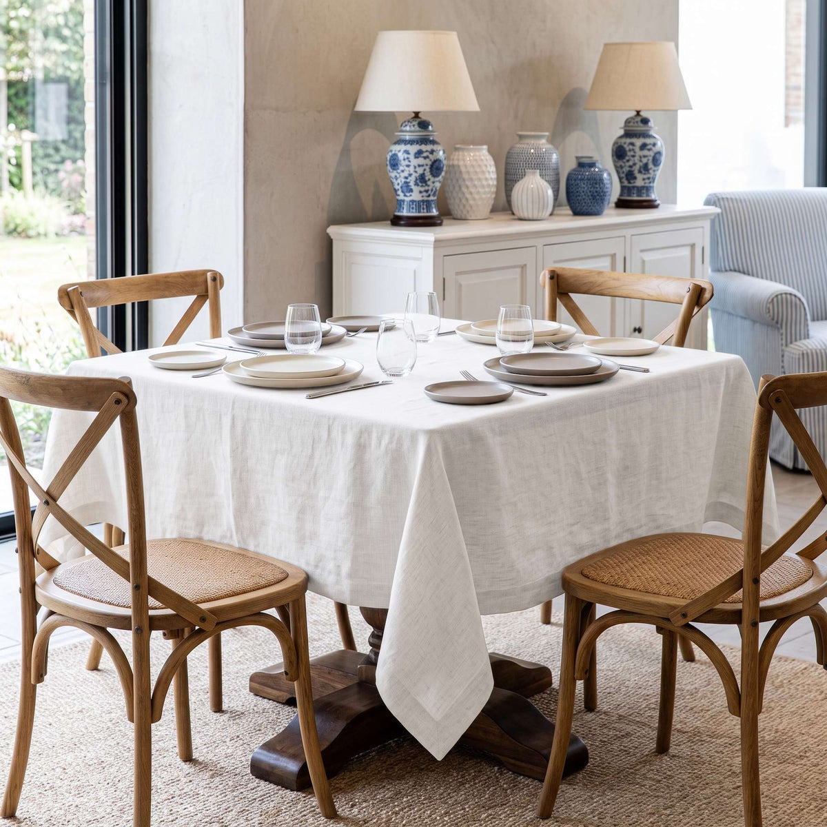 Off-White Square Linen Tablecloth in a Transitional Dining Room with Wooden Cross-Back Chairs